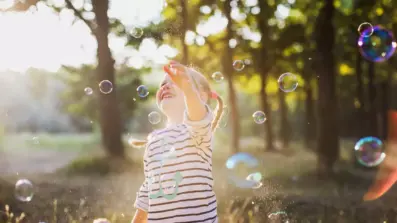 pcs image3 young child in a forest blowing bubbles