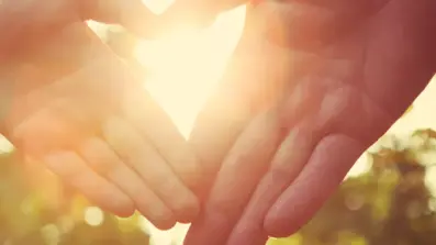 pcs image5 two hands creating a heart shape in the centre with the sun shining through
